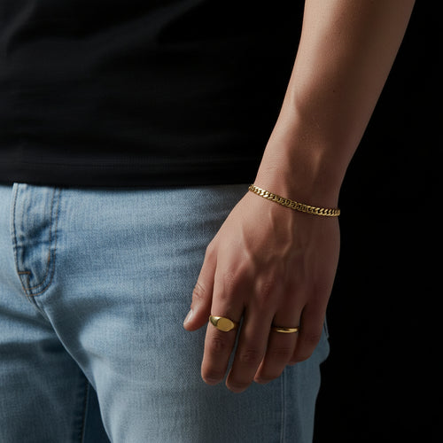 Gold chain bracelet on a wrist with a blurred background